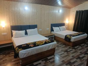 two beds in a room with two beds sidx sidx sidx sidx at Serene River Cottages Sadhupul in Jūnga