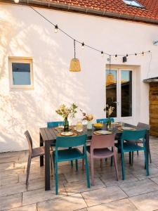 a patio with a wooden table and chairs at Gite Les 4 Moustaches in Bourbourg