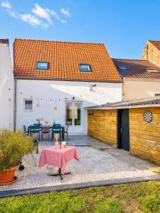 a patio with a table in the backyard of a house at Gite Les 4 Moustaches in Bourbourg