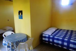 クムルサティバにあるPousada Sol Nascenteのベッドとテーブルと椅子のある小さな部屋 +24枚の写真