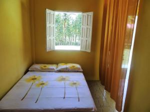 a bedroom with two beds in front of a window at Pousada Sol Nascente in Cumuruxatiba