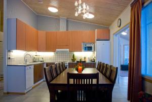 a kitchen with a table and chairs in a kitchen at VILLA PUUSTILA (6 mh) in Tahkovuori +7 photos