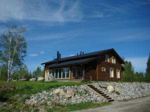 a wooden house with rocks in front of it at VILLA PUUSTILA (6 mh) in Tahkovuori