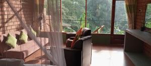a woman sitting in a chair looking out the window at Ayanura Ella in Ella