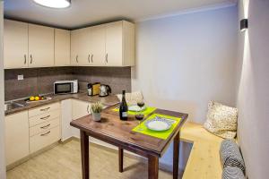 a small kitchen with a table with a bottle of wine at Sunrise Suite in Kavála