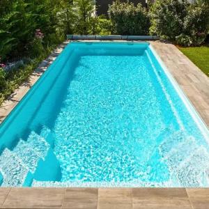 a swimming pool with blue water in a yard at Садиба in Vinnytsya