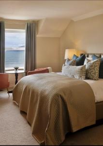 a bedroom with a large bed with a view of the ocean at Butler Arms Hotel in Waterville