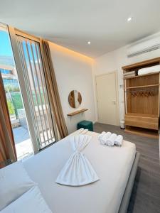 a bedroom with a white bed with towels on it at Villa Central Palms in Palasë