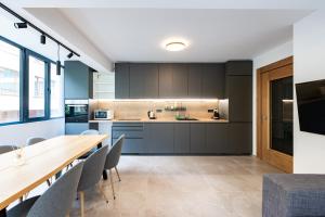 an open kitchen and dining room with a wooden table and chairs at Vitosha Park Apart in Sofia