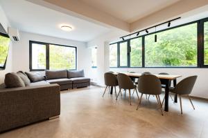 a living room with a couch and a table and chairs at Vitosha Park Apart in Sofia