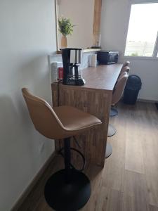 a row of chairs sitting at a bar in a room at L'Escale de la Râperie logement 4 in Tincourt-Boucly