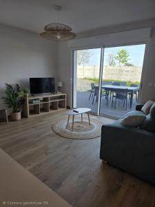 a living room with a couch and a table at L'Escale de la Râperie logement 4 in Tincourt-Boucly