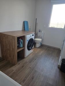 a bathroom with a washing machine and a toilet at L'Escale de la Râperie logement 4 in Tincourt-Boucly +9 photos