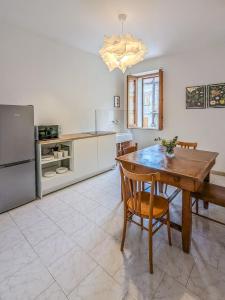 a kitchen with a wooden table and a refrigerator at Casa Mare e Sole in Vibonati