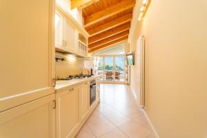 a kitchen with white cabinets and a large window at The A-LINE Lake COMO view apt A with pool & garage in Tremezzo