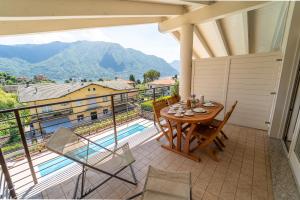 a balcony with a table and chairs and a view at The A-LINE Lake COMO view apt A with pool & garage in Tremezzo