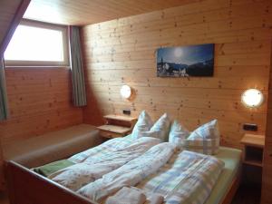 ein Schlafzimmer mit einem Bett in einer Holzwand in der Unterkunft Haus Mittergries in Tux