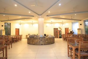 a banquet hall with wooden chairs and a bar at The Corbett Manral Resort in Rāmnagar
