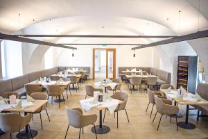 a restaurant with tables and chairs in a room at Schloss Hotel Zeillern in Zeillern