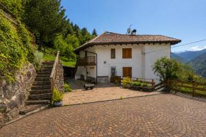 a small white house with a staircase in front of it at Maso Simoni - Bazzanella in Piscine di Sover