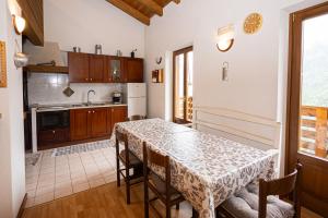 a kitchen with a table with chairs and a table and a table and a kitchen at Maso Simoni - Bazzanella in Piscine di Sover