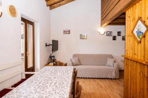 a living room with a bed and a couch at Maso Simoni - Bazzanella in Piscine di Sover