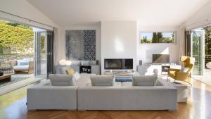 a living room with a white couch and chairs at BelleVue Cala Vinyes in Cala Vinyes