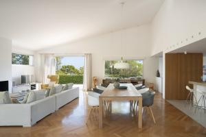 a living room with white furniture and a table at BelleVue Cala Vinyes in Cala Vinyes