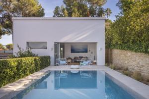 a swimming pool in a backyard with a house at BelleVue Cala Vinyes in Cala Vinyes