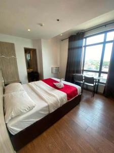 a bedroom with a large bed with a red blanket at JLux Hotel in Manila