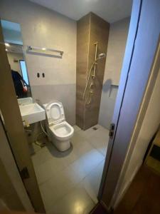 a bathroom with a toilet and a sink and a shower at JLux Hotel in Manila