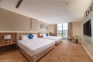 a hotel room with two beds and a television at Solaya Hotel in Tài Xá