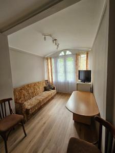 ein Wohnzimmer mit Sofa und Tisch in der Unterkunft Hotel Elīna in Jūrmala