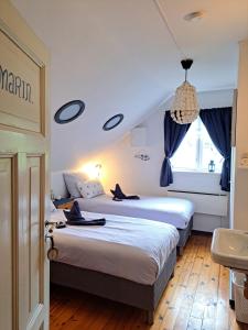 two beds in a hotel room with blue curtains at Elvebakk Bed & Breakfast in Reed