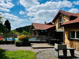 a house with a patio and a swimming pool at Chalet Les Prés Chaussottes in Gérardmer