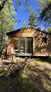 a house with a table and chairs in front of it at Hôtel et Camping O2 Orcières Outdoor Area in Orcières +48 photos