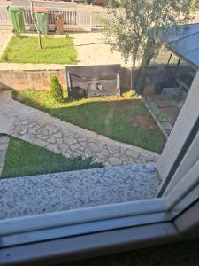 a view of a yard with a bench in the grass at Apartmani Željko in Zadar