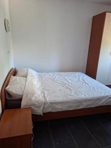 a bedroom with a bed with a wooden frame and a table at Apartmani Željko in Zadar