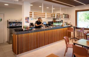a man standing behind a bar in a restaurant at Gran Camping Zarautz in Zarautz