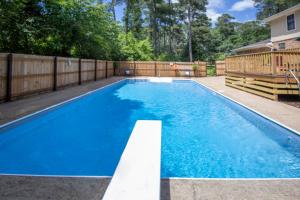 a swimming pool in a backyard with a wooden fence at Blindfrog in Scottsboro