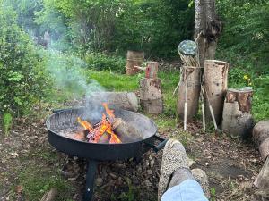 a person is cooking food on a grill at Cozy Garden Glamping in Svendborg