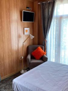a bedroom with a bed and a chair and a television at La Cassola del Priorat in Gratallops