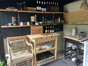 a kitchen with a table and a chair and shelves at Cozy Garden Glamping in Svendborg +30 photos