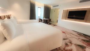 a hotel room with a large white bed and a television at The Federal Kuala Lumpur in Kuala Lumpur
