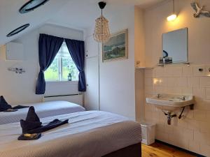 a bedroom with two beds and a sink and a mirror at Elvebakk Bed & Breakfast in Reed