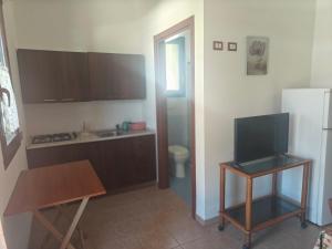 a kitchen with a refrigerator and a table with a television at Gli Ulivi Residence in Leverano +159 photos