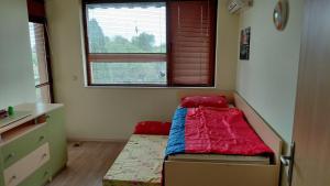 a small bedroom with a bed and a window at Вила Зеленка - Villa Zelenka in Bŭlgarevo