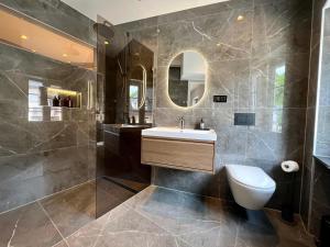 a bathroom with a sink and a toilet and a mirror at Auberge de Vianden in Vianden