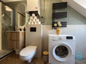 a bathroom with a toilet and a washing machine at Casa Verde Apartment at Old Town Gdańsk in Gdańsk +27 photos