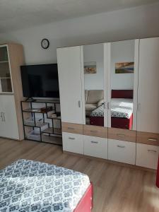 a bedroom with two beds and a large cabinet with a television at Ferienwohnung Michelle in Bremerhaven